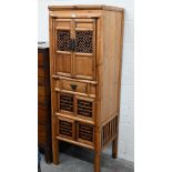 A stained fir Chinese pantry cupboard with open-trellis fretwork panelled doors and single drawer,