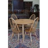 A mid-century Ercol Windsor elm and beech oval breakfast table with spindled undertier on splayed