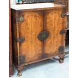 An Oriental style walnut two door cocktail/side cabinet with engraved brass mounts, shell carved