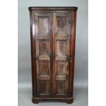 An 18th century and later composed tall oak corner cupboard, with pair of panelled doors enclosing