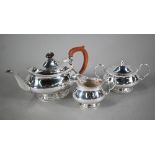 A heavy quality silver three-piece tea service of oval pot-bellied form with moulded rims and raised