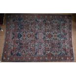 A good antique Persian Sarouk carpet, the field of repeating stylised flowers on dark blue ground,