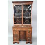 A composite George III mahogany kneehole secretaire bookcase, the associated astragal glazed upper
