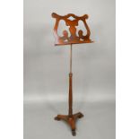 A Victorian mahogany single music stand, with brass rise and fall pole on a tri-form platform base