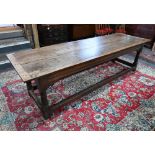 A large 17th century oak refectory table, the twin wide plank top within cleated ends and narrow