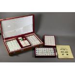 A vintage Chinese velvet cased Mah-Jong set with bone and bamboo tiles including three complete
