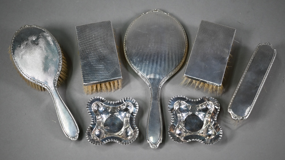 Four engine-turned silver hairbrushes and a hand-mirror, Birmingham 1957, to/w two quatrefoil pin- - Image 2 of 5