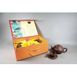 A boxed Chinese Yixing pottery tea set comprising a compressed globular teapot and cover with