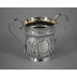 A late Victorian loving cup in the Carolean manner, with reeded strap handles and embossed