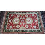An Indian Agra rug, the coral ground with stylised flower design, 198 cm x 121 cm (two localised