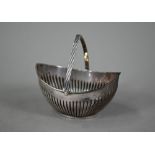 An Edwardian silver sugar basin of half-reeded elliptical form with swing handle, Barker Brother,