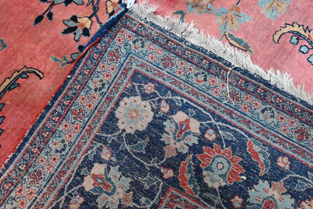 A large old pink ground Persian Sarouk carpet with navy blue floral border, 470 cm x 322 cm - Image 4 of 4