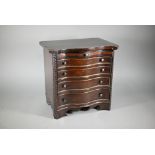 An miniature mahogany serpentine chest of four long graduated drawers, in the Chippendale style with