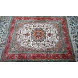 A Persian Tabriz part silk rug, the floral design on cream ground centred by a medallion, 190 cm x