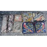 An assortment of eight antique needlepoint faced cushions including a companion pair of parrot theme