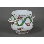 A Dresden porcelain cache-pot with twin handles, painted with floral garlands intertwined with green