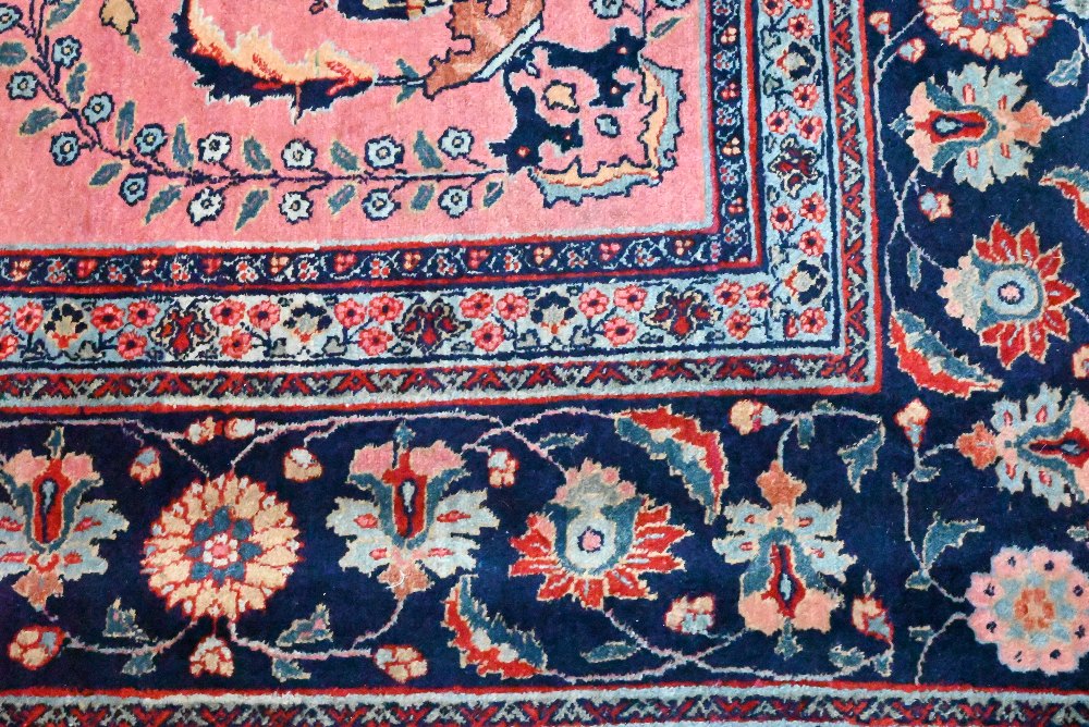 A large old pink ground Persian Sarouk carpet with navy blue floral border, 470 cm x 322 cm - Image 3 of 4