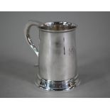 A silver half-pint mug in the Georgian manner, with scroll handle and moulded foot-rim,