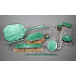 An Art deco silver and green guilloche enamel toilet set, comprising five jars and bottles and a