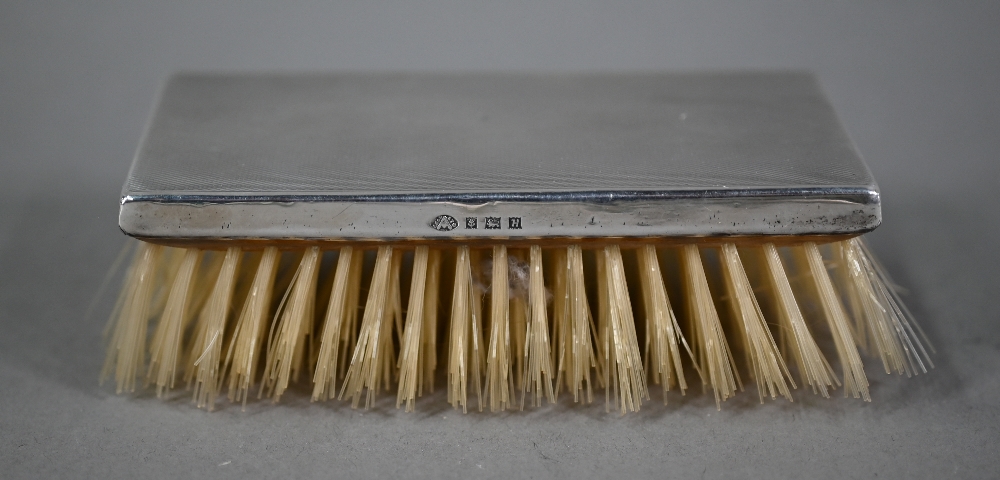 Four engine-turned silver hairbrushes and a hand-mirror, Birmingham 1957, to/w two quatrefoil pin- - Image 5 of 5