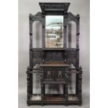 A Victorian carved oak mirror backed hall stand, with cupboard and twin stick stands, 119 cm w x