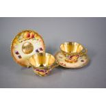 A pair of Royal Worcester cabinet tea cups and saucers, painted with fruit still lives, signed S.