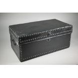 An antique studded black clad leather trunk, with carrying handle to each side, 57 cm x 30cm x 26 cm