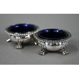 A pair of William IV silver circular open salts in the Regency manner, with blue glass liners and