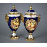 A pair of boxed Coalport blue-ground urns and covers, the reserves painted with fruit still lifes,