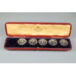A cased set of five silver buttons with open scroll decoration, 1901, in fitted case for six buttons