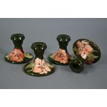 A set of four Moorcroft green hibiscus candlesticks, with impressed stamps (one with paper 'Late