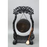 A 19th century Chinese circular bronze gong suspended from the ebonized hardwood frame (later