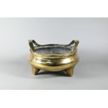 A large 19th century Chinese bronze tripod censer, compressed globular form with loop handles