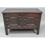 A late 17th century oak coffer, with applied geometric moulded front panels, raised on stiles -