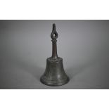 An antique bronze hand-bell with stylised floral-bud finial, 27 cm high