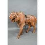 A large and substantial hand carved solid teak sculpture of a tiger, approx. 150 cm long x 114 cm h