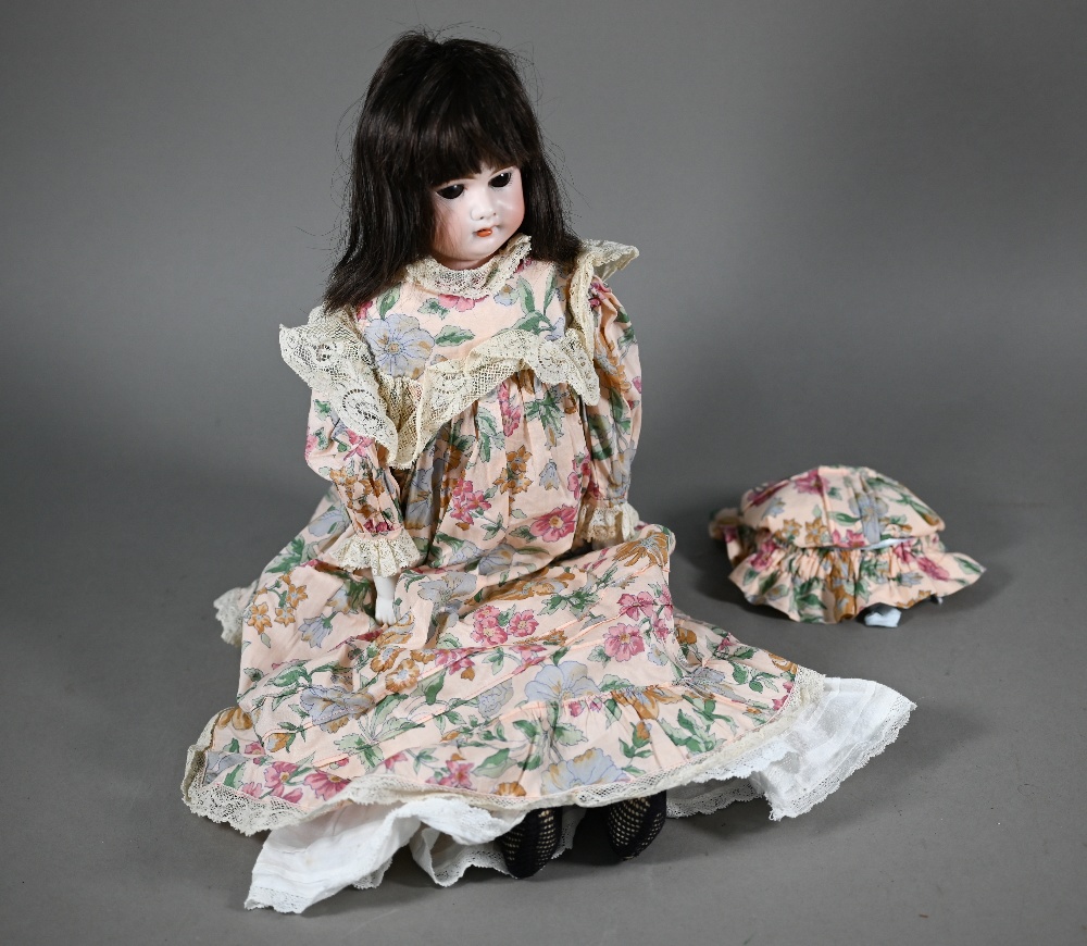 An Armand Marseille no 3500 AM 2 1/2D bisque-headed girl doll with brown wig, closing brown eyes and