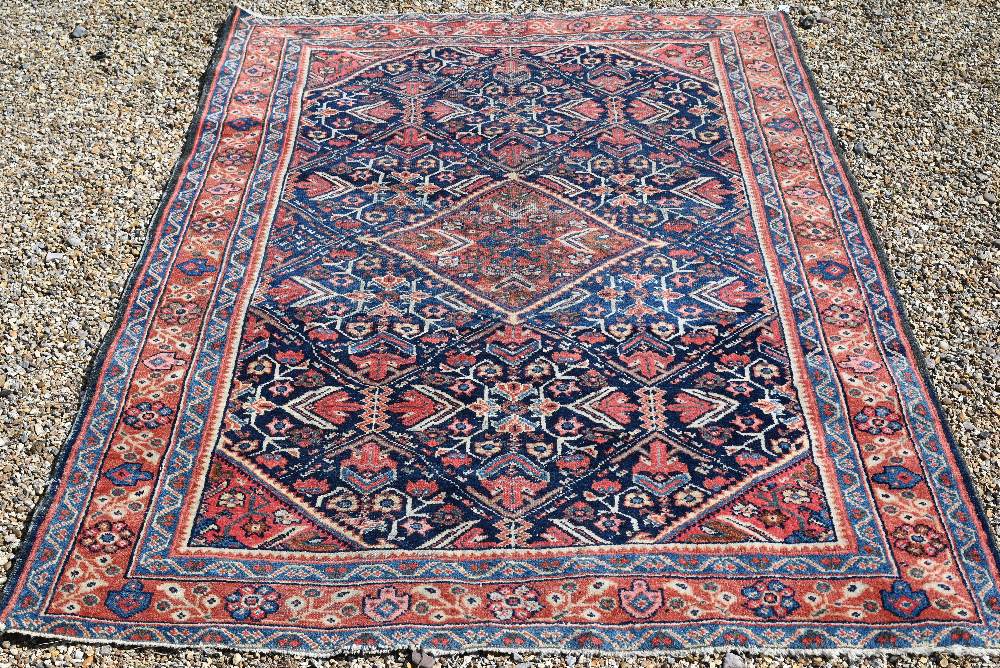 An old Persian Mahal rug, the blue ground centred by a medallion, 202 cm x 140 cm