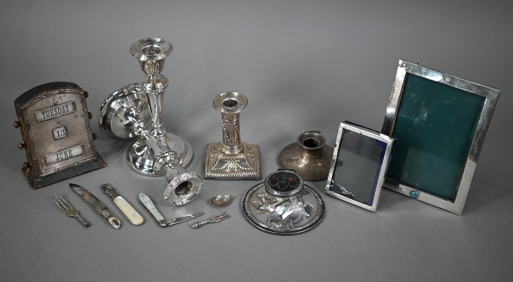 A quantity of loaded silver items including candlesticks, desk calendar, inkwells, photograph