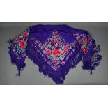 A circa 1930s Chinese silk 'piano' shawl, the purple ground profusely decorated with flowers in