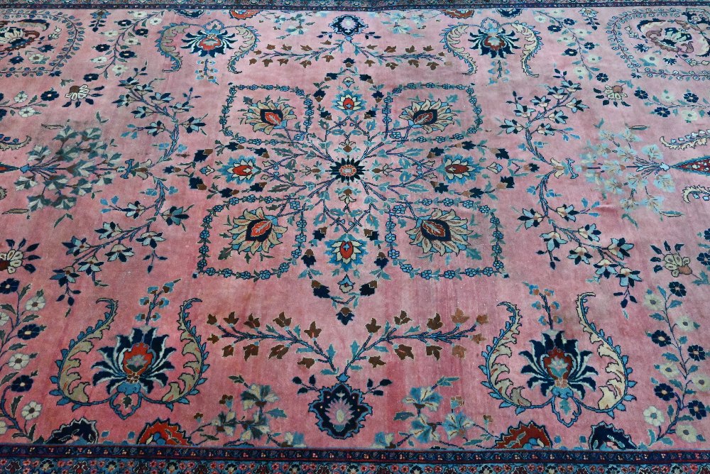 A large old pink ground Persian Sarouk carpet with navy blue floral border, 470 cm x 322 cm - Image 2 of 4