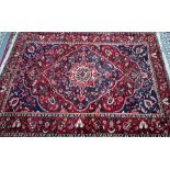 A Persian Hamadan carpet, the red/blue ground centred by a medallion, 300 cm x 207 cm