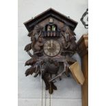 A German Schneider carved wood cuckoo clock with revolving dancing couples below the cuckoo, above
