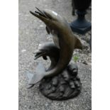 A cast weathered bronze patinated twin dolphin water feature