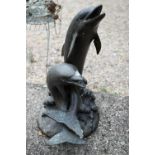 A cast weathered bronze patinated twin dolphin water feature