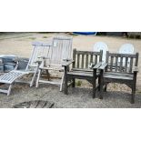 A weathered teak steamer chair with foot extension, to/w a reclining teak armchair and a pair of
