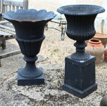 A classic cast iron garden urn planter on square plinth base to/w another of flared neck design -