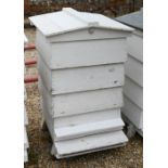 A traditional wooden bee hive, painted white