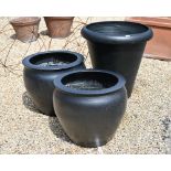 A large black surface finished terracotta planter 70 cm dia. x 73 cm h to/with a smaller pair 57