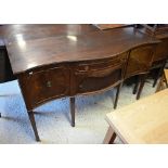 A mahogany serpentine front sideboard, centred by a frieze drawer over a tambour cupboard flanked by